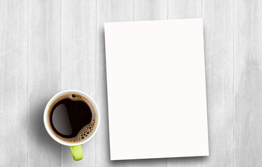 Blank greeting card and coffee on white wooden table background.