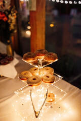 tower of fancy donuts at night for wedding treat table