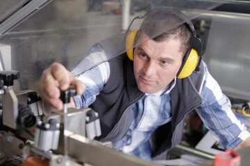 portrait of male engineer working on machine in factory