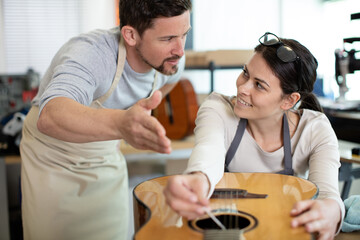 two young people fixing guitars