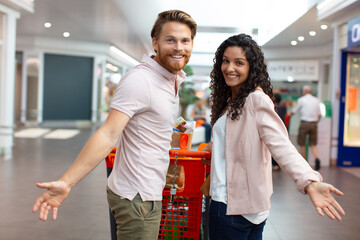 Obraz premium happy couple with a shopping cart