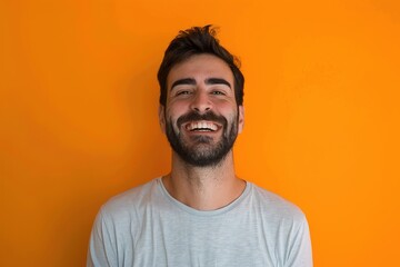 Fototapeta premium A man with a beard and a smile is standing in front of an orange wall