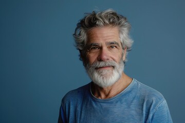 Fototapeta premium A man with a beard and gray hair is smiling at the camera