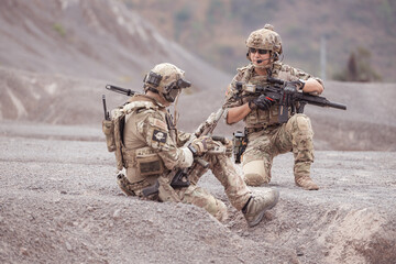 Soldiers in camouflage military uniforms carrying weapons, Reconnaissance missions in rugged...