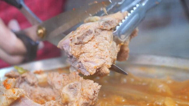 묵은지 갈비전골의 잘 익은 돼지갈비를 가위로 잘라 보글보글 끓이는 모습