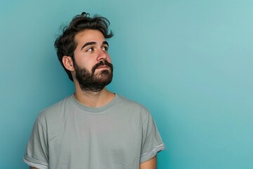Fototapeta premium A man with a beard and a gray shirt is looking at the camera