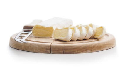 Whole and sliced cheese on wooden board