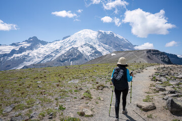 Woman hiking the Sunrise Trail. Mt Rainier in the background. Mt Rainier National Park. Washington State.