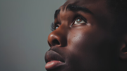 Beautiful young black man looking up with tears in her eyes.