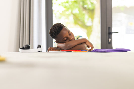 African American boy appears bored with his head resting on his arms