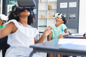 Biracial children are exploring virtual reality in a classroom setting in school