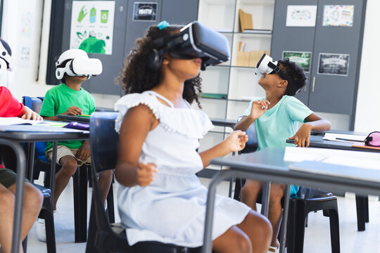 Diverse children are using virtual reality headsets in a classroom in school