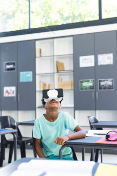 Biracial boy wearing virtual reality headset in a classroom in school