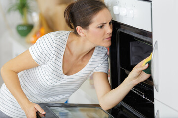 woman cleaning inside an oven