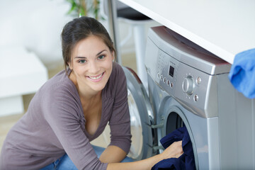 happy woman in laundry room with washing machine