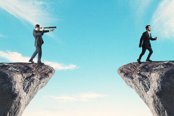 Side view of businessmen with telescope on cliff edge on bright blue sky background. Future, team,...
