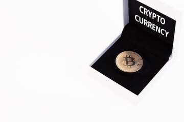 Cryptocurrency text, golden bitcoin in a white gift box with black velvet on a white background. Copy space.