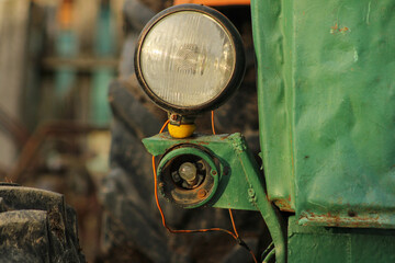 A warm evening in the tractor has a battered headlight.