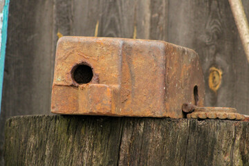 An old rusty anvil in the background of a wooden garage. Close-up