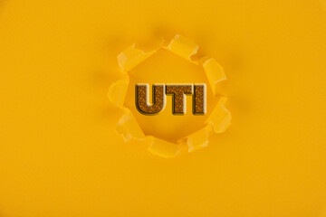 UTI abbreviation urinary tract infection, concept, yellow background.