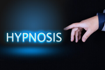 HYPNOSIS text, word written in neon letters on a black background pointed to by a hand with a...