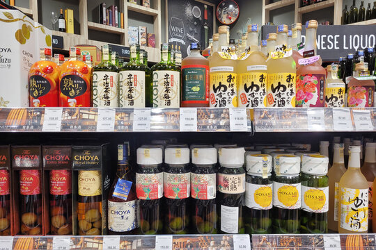 Penang, Malaysia - 22 JAN 2024: A variety of Japanese wine and hard liquor bottles are neatly displayed on store shelves at Aeon Grocery store in Malaysia.