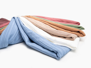 Multicolored fabrics folded in a stack top view on a white background. Multi-colored textile