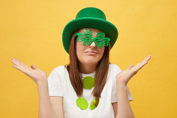 Fun and festive Irish party. Greetings for Irish celebrations. Uncertain woman wearing festive...