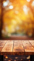 An empty brown wooden countertop on a blurred autumn background on a sunny day. Vertical photo for Product presentation, Advertising, Copy space. - obrazy, fototapety, plakaty