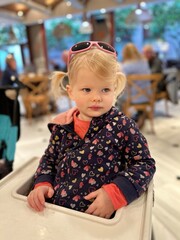 Jeune fille de 2 ans et demi assise au restaurant