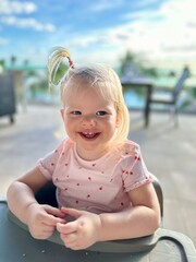 Jeune fille de 2 ans souriant sur fond de vacances exotiques