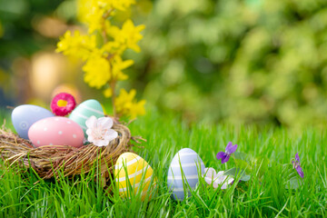 Green spring landscape with blossoms and flowers and Easter eggs as a postcard with an Easter basket. - 756276430