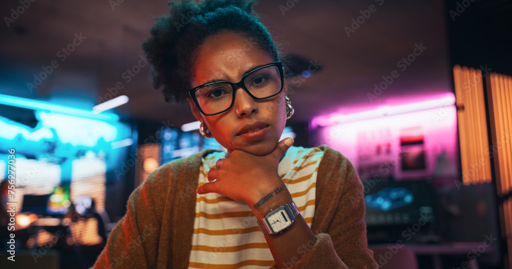 Aufkleber Stylish Young Black Woman Looking at Camera With Confusion While Working on Desktop Computer in Creative Office. Female Developer Trying to Fix a Bug, Unsure of the Source of the Issue
