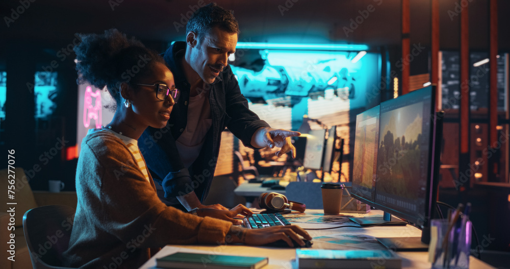 Fototapete Two Stylish Diverse Employees Discussing Level Landscape on Computer in Game Development Company. Young Creative Director and Designer Talking About Work, Making Changes on Project