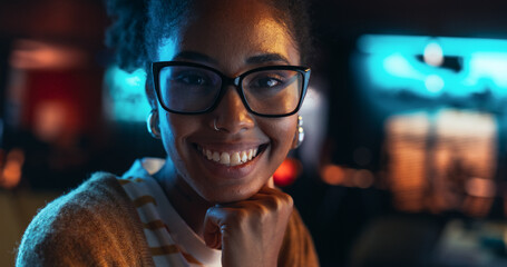 Close Up Portrait of a Young Black Woman with Glasses, Looking at Camera, Smiling in a Creative...