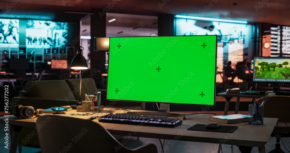 Poster Desktop Computer with Mock Up Green Screen Chroma Key Display Standing on the Desk in the Empty Creative Office Lit by Neon Lights. Monitor in Game Development or Animation Company