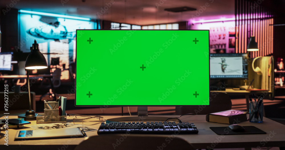 Poster Desktop Computer with Mock Up Green Screen Chroma Key Display Standing on the Desk in the Empty Creative Office Lit by Neon Lights. Monitor in Game Development or Animation Company