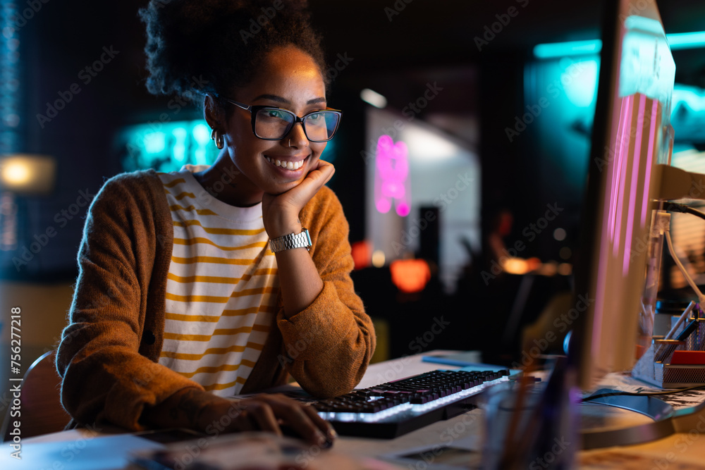 Poster african american female smiling while checking data and statistic charts using desktop computer. por