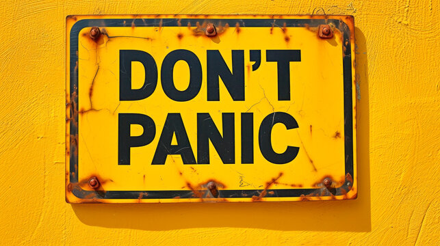 Bright yellow cautionary sign with bold black letters spelling DON'T PANIC, conveying a message of staying calm and not overreacting in challenging situations