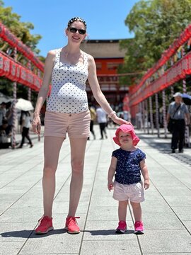 Enfant fille de 1 an et demi se tenant à côté de sa maman enceinte devant une pagode Japonaise au Japon