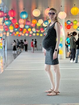Jeune femme enceinte devant une décor de luminaires colorés suspendus