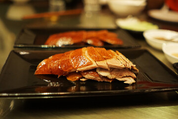 Roasted honey Peking duck served with Chinese pancake roll, spring onions, cucumber and sweet bean Hoisin sauce