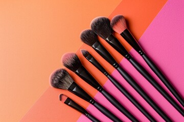 still life makeup brushes and powder on pink and orange background
