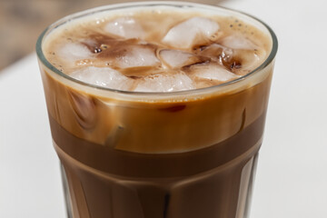 cappuccino with ice. There is a chocolate cappuccino with ice cubes in a large transparent glass, close-up, drink concept