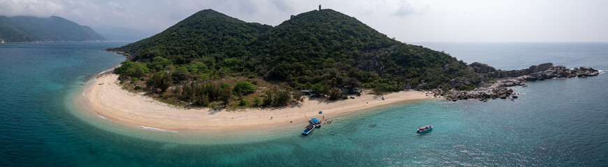 Panoramic aerial drone view of spectacular white sand beach of tropical Hon Nua Island off the Central Vietnam coast, surrounded by the pristine turquoise water of the South China Sea