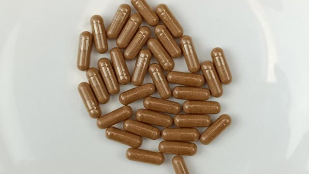 tas de g&eacute;lules dans une assiette vide, en gros plan.	