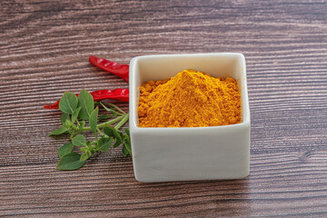 Yellow vibrant curcuma powder in the bowl