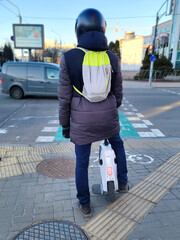 Man on electric unicycle stands on zebra crossing, driving single wheel. Commuting to work on...