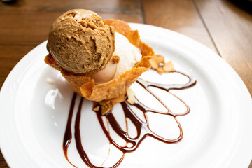 Variety of Refreshing Ice Cream Scoops in Waffle Cone with Salted Caramel Sauce on White Plate - Chocolate, Coffee, Lemon, Vanilla Flavours