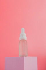 Plastic white tube for cream or lotion. Skin care or sunscreen cosmetic  with stylish props on pink background.